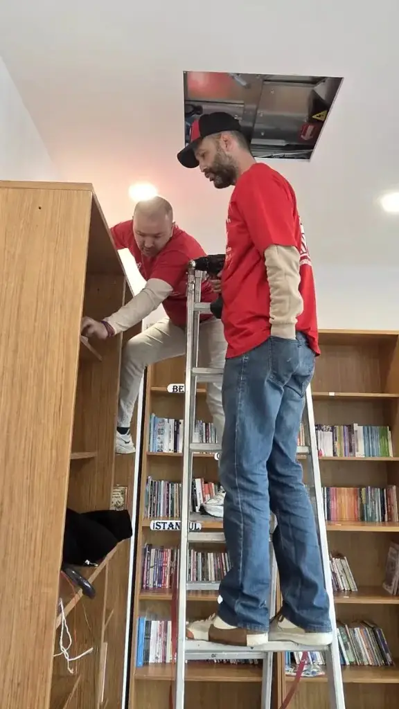 RED DAY gününde merdivene çıkıp kütüphane tadilatı yapan KW danışmanları